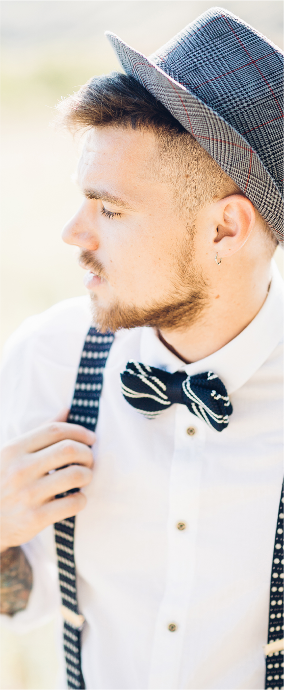 young man in navy striped bow tie and braces